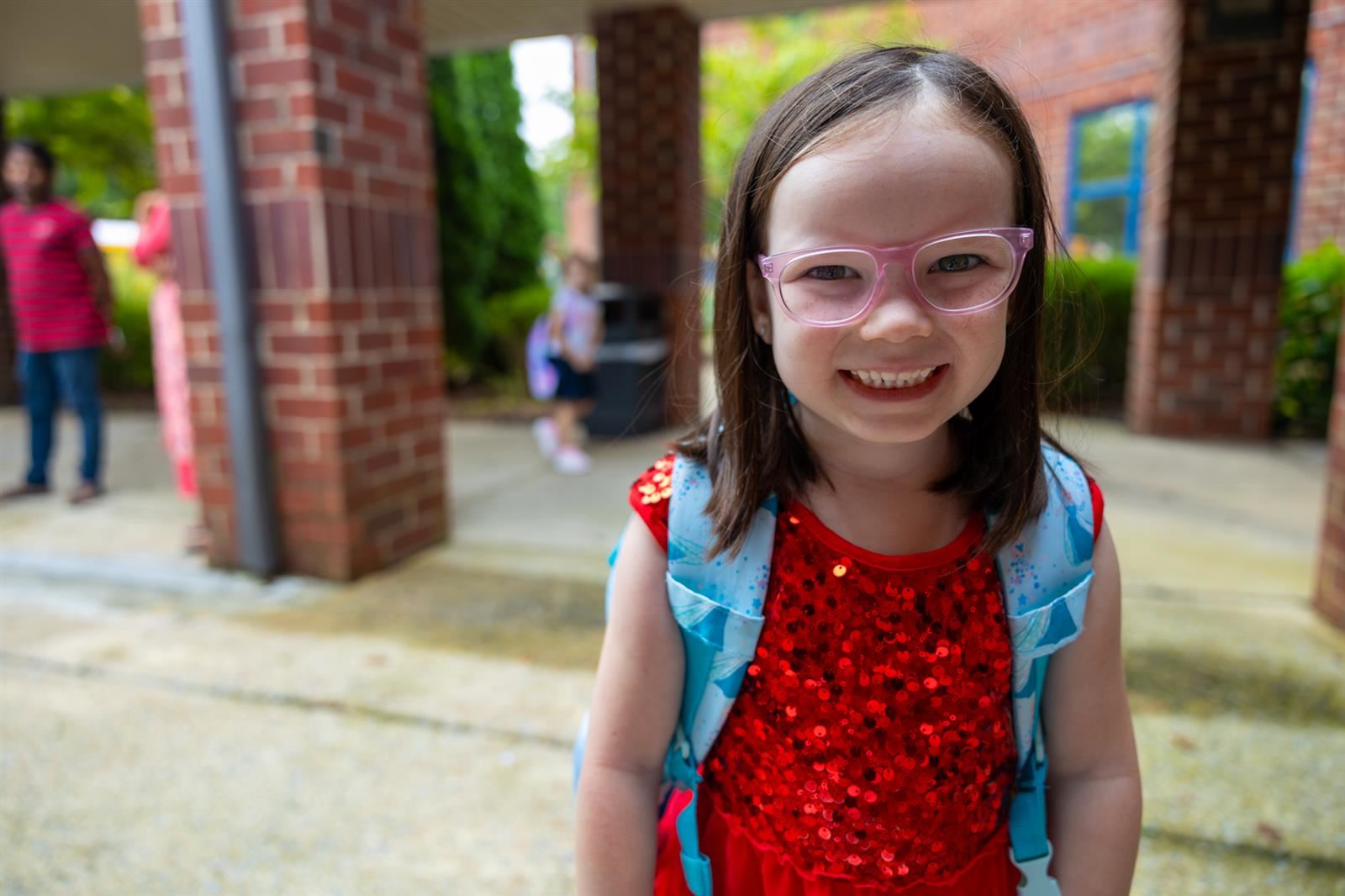 girl in red shirt and pink glasses
